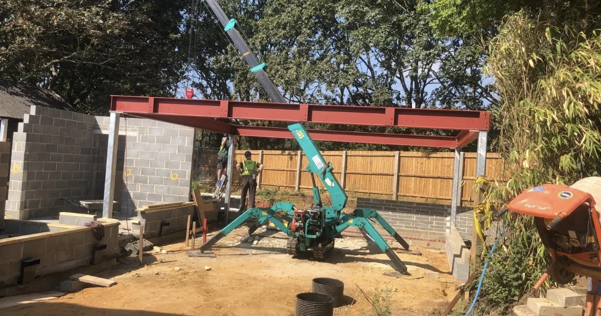 Spider crane assisting with positioning structural steelwork