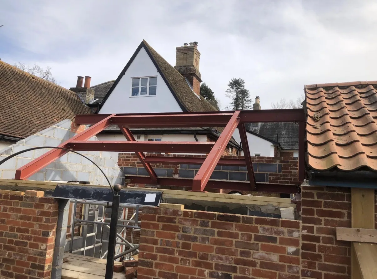 Red structural steel frame installed at a home extension