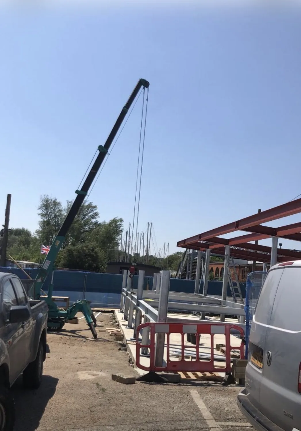 Spider crane operating alongside a structural steel frame