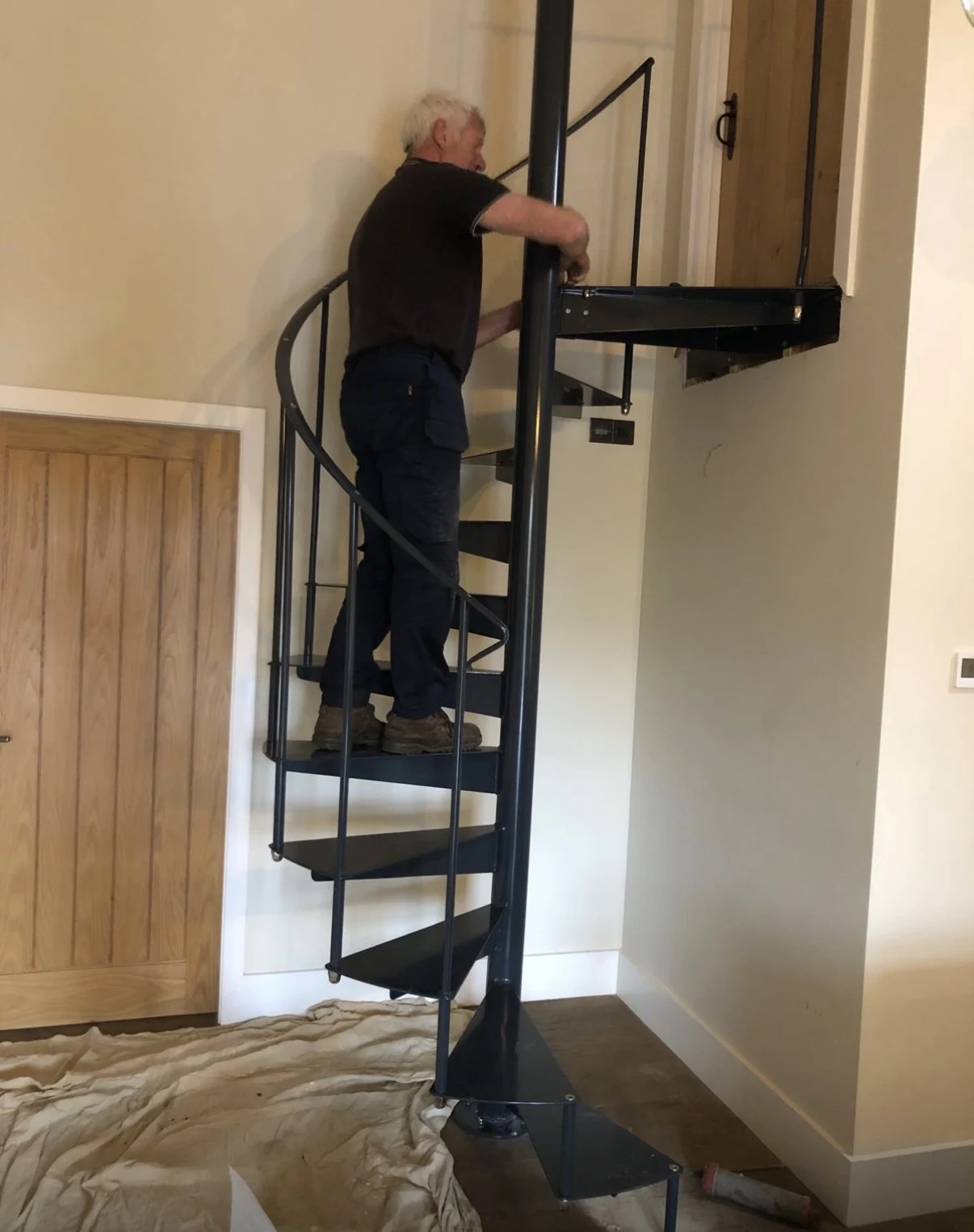 Black spiral steel staircase installed inside a property